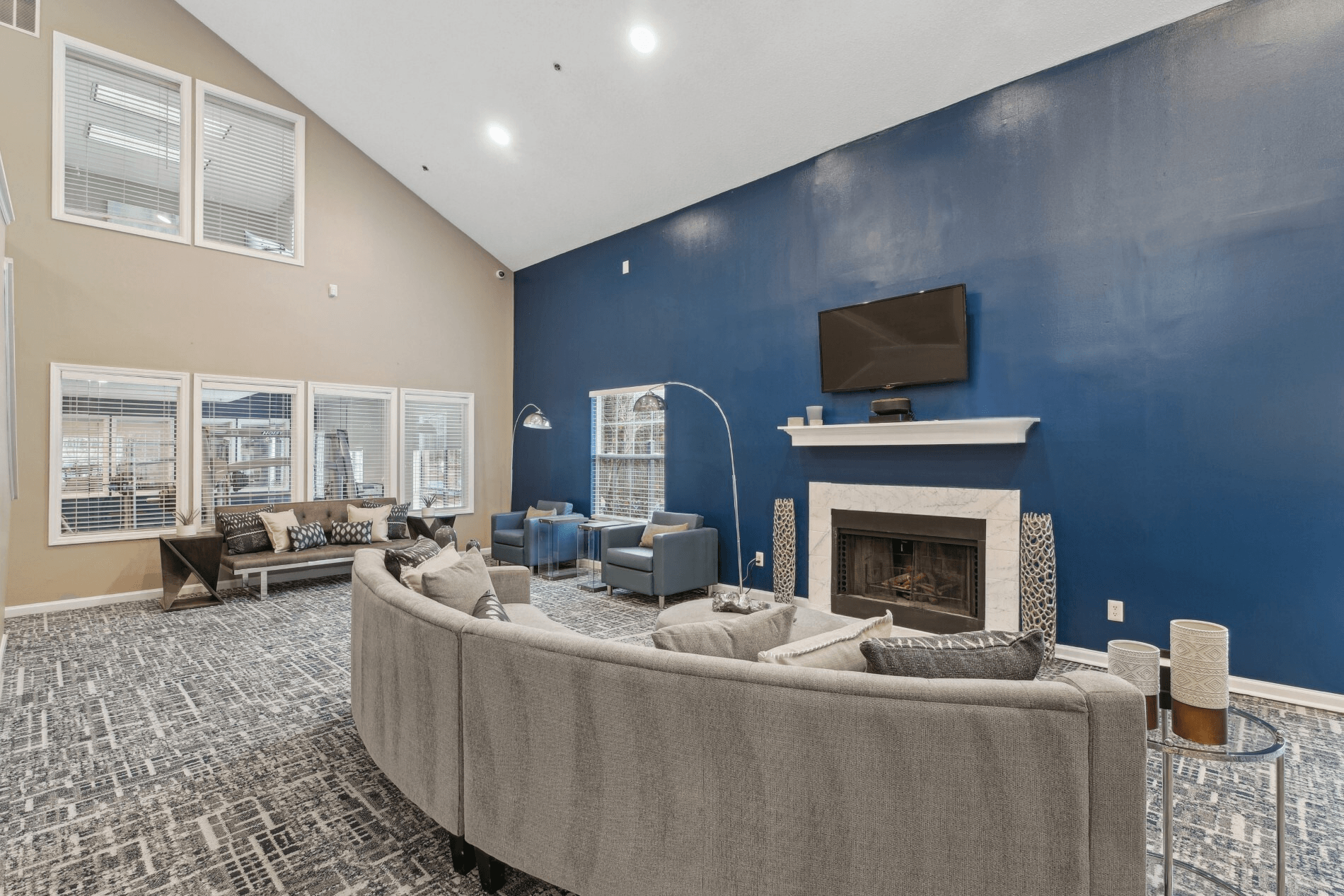 A living room with a grey couch and a fireplace.