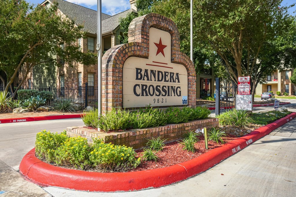 Welcoming entrance sign at Bandera Crossing apartments in San Antonio, TX