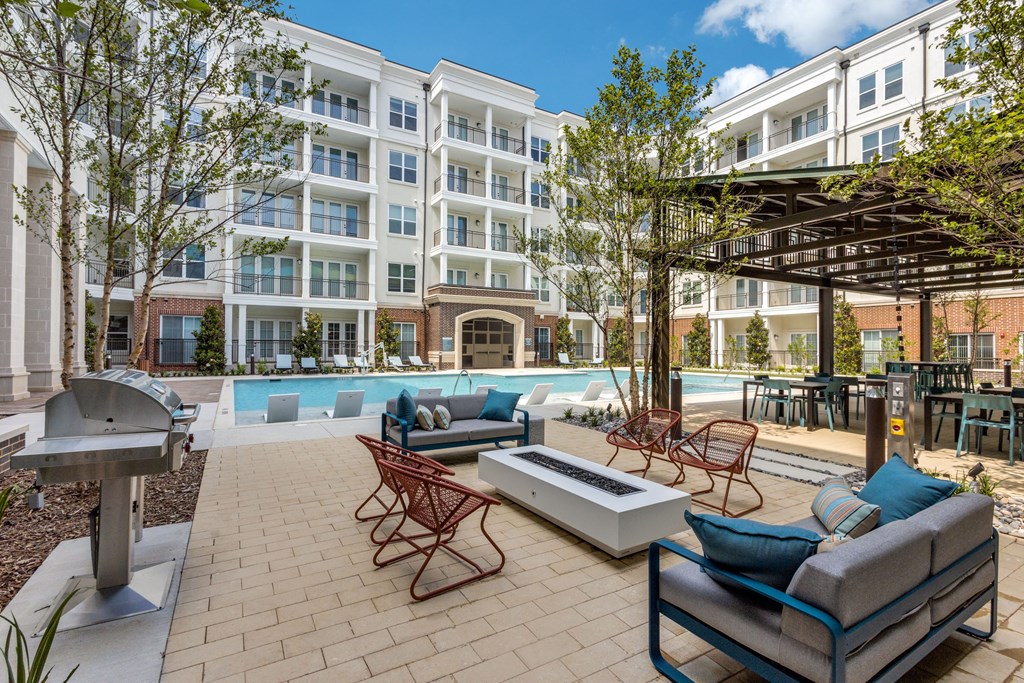 Outdoor seating around the fire pit by the pool at Era Apartments in Denton, TX