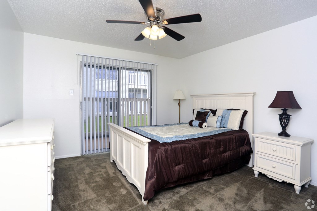 a bedroom with a bed and a ceiling fan