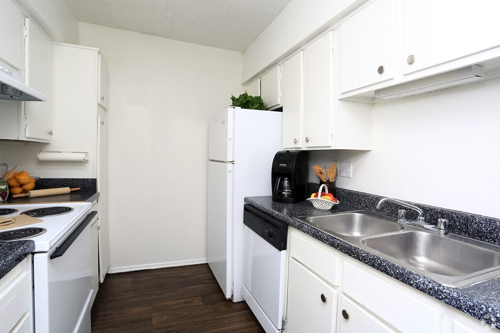 a kitchen with white cabinets and a sink and a refrigerator
