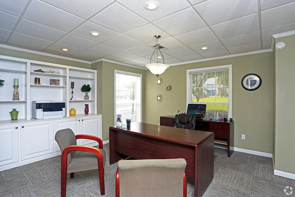 a home office with a wooden desk and chairs