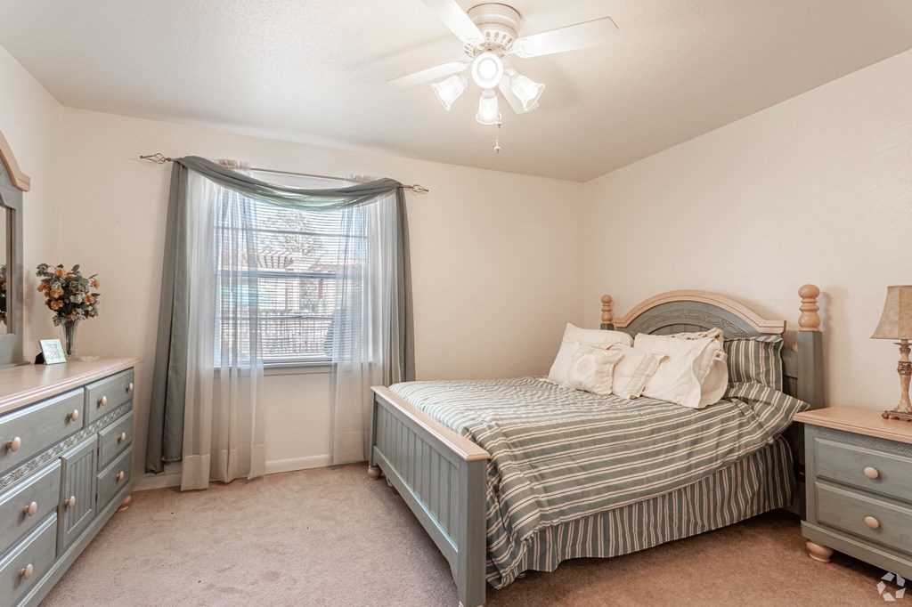 a bedroom with a bed and a ceiling fan