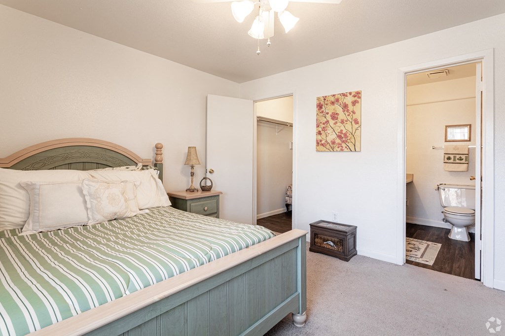 a bedroom with a bed and a bathroom with a toilet