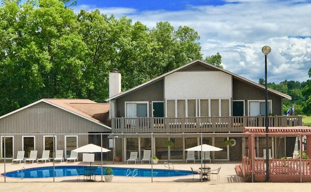 a house with a swimming pool and a patio with umbrellas