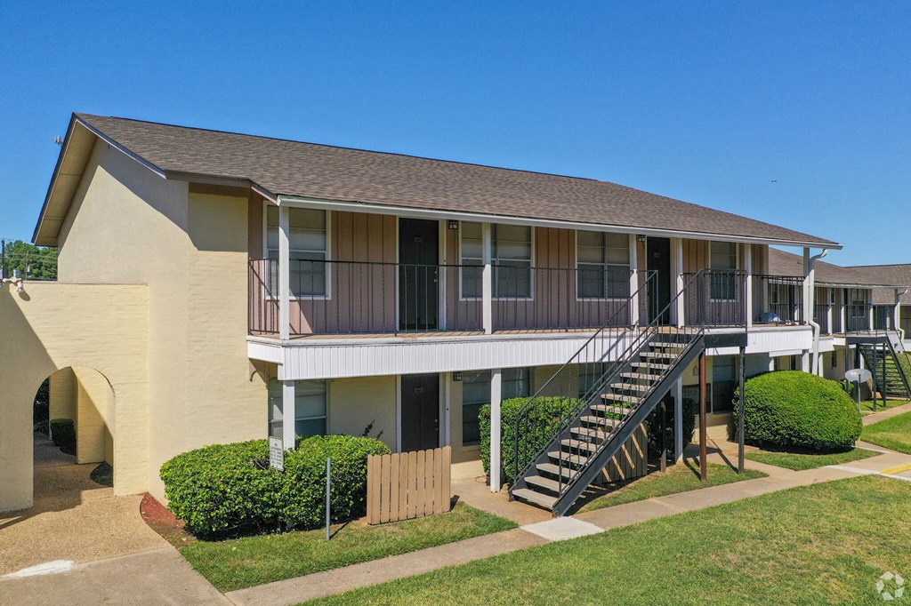 an exterior view of a building with a deck and a staircase