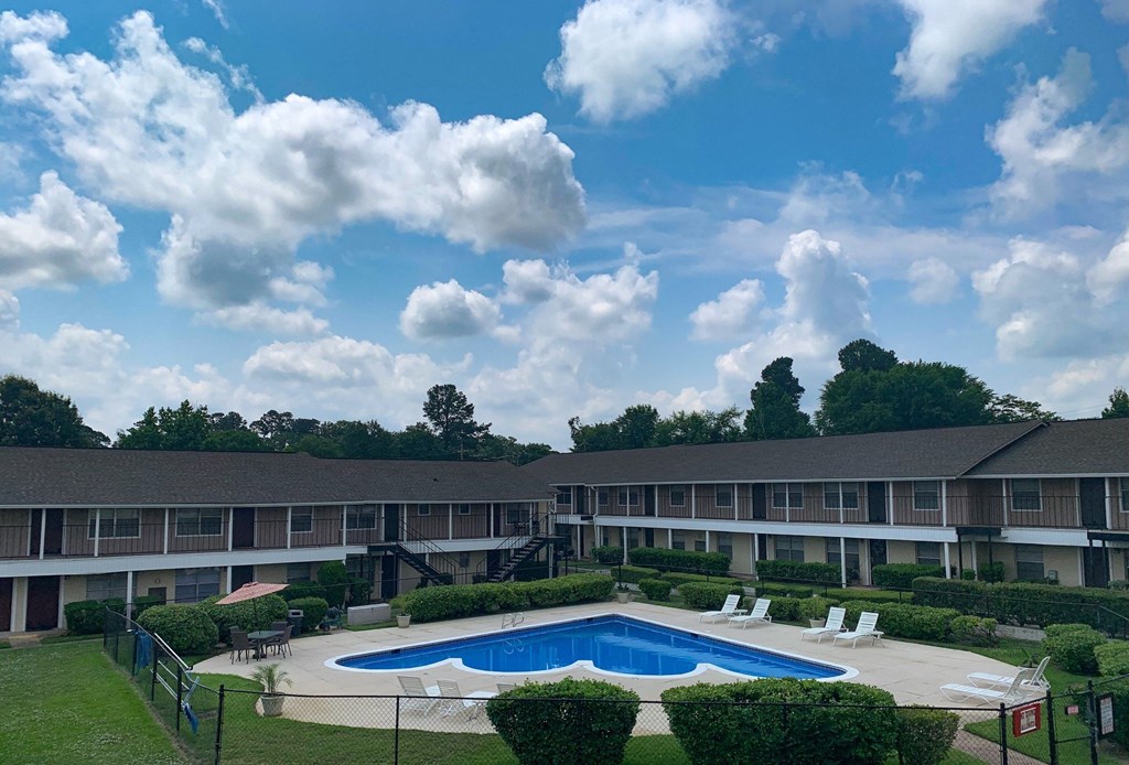 an aerial view of a swimming pool in front of an apartment building
