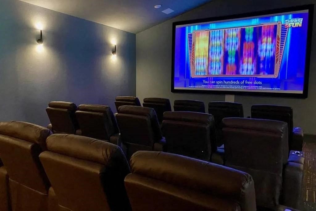a theater room with leather chairs and a projection screen of Avery Oaks in Austin, TX