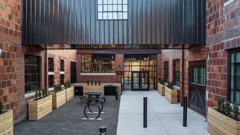 A courtyard with a table and chairs surrounded by brick walls.