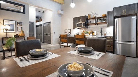A modern kitchen with a dining table set for two.