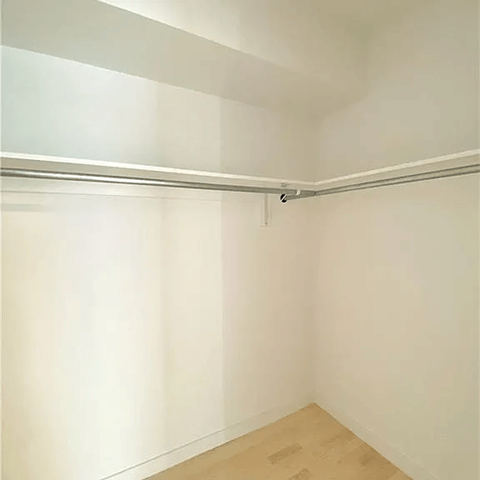 A white wall with a wooden floor and a white ceiling.