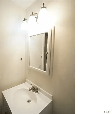 A bathroom with a sink and mirror.