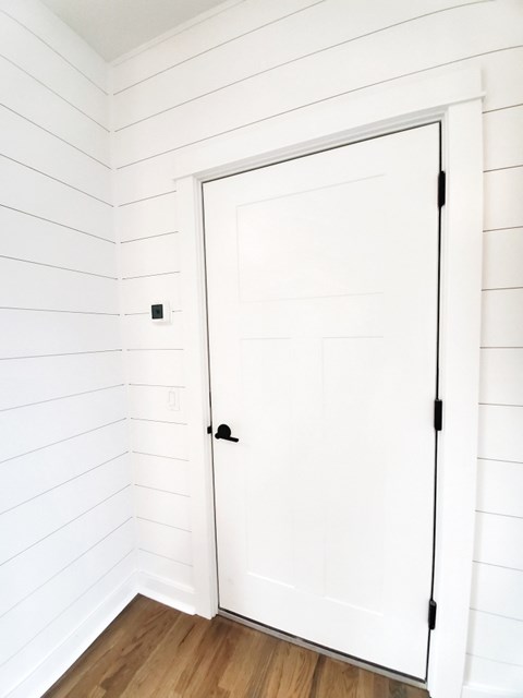 A white door is in a room with white walls.