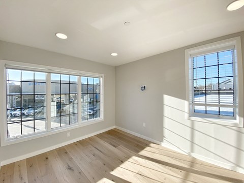 A sunny room with a view of the street outside.