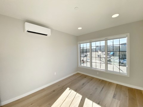 A room with a window and a wall-mounted air conditioner.