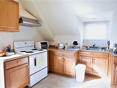 A kitchen with wooden cabinets and white appliances.