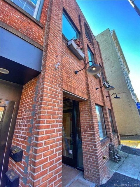 A red brick building with a black door and windows.