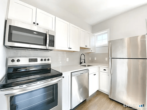 A kitchen with white cabinets and stainless steel appliances.