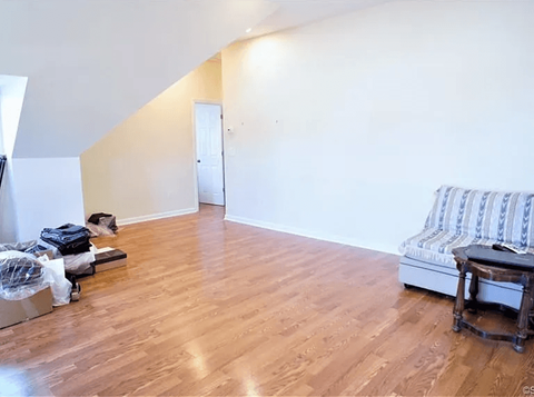 A room with a wooden floor and a sofa.