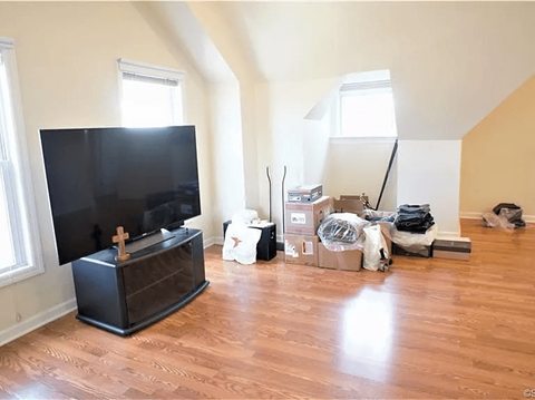 A room with a television and boxes on the floor.