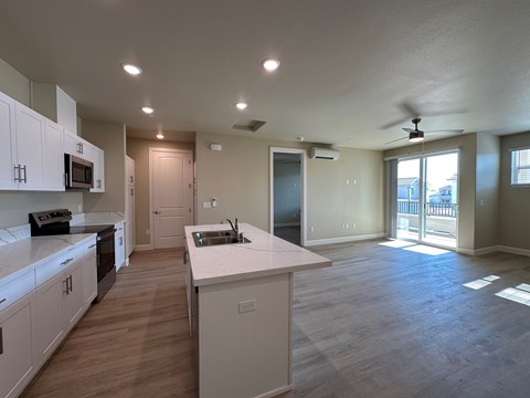 A kitchen with white cabinets and a large island.