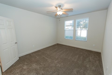 a bedroom with carpet and a ceiling fan