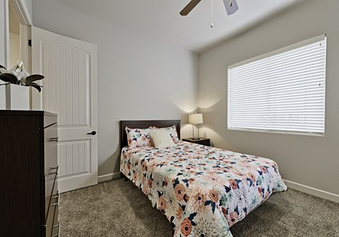 a bedroom with a bed and a ceiling fan