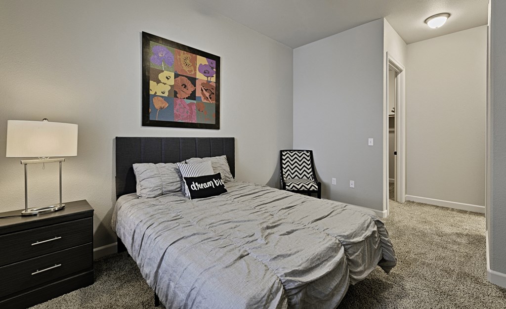 a bedroom with a queen sized bed and a painting on the wall