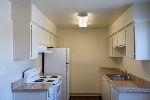 A small kitchen with a white stove and a refrigerator.