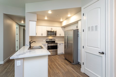 a renovated kitchen with white cabinets and stainless steel appliances