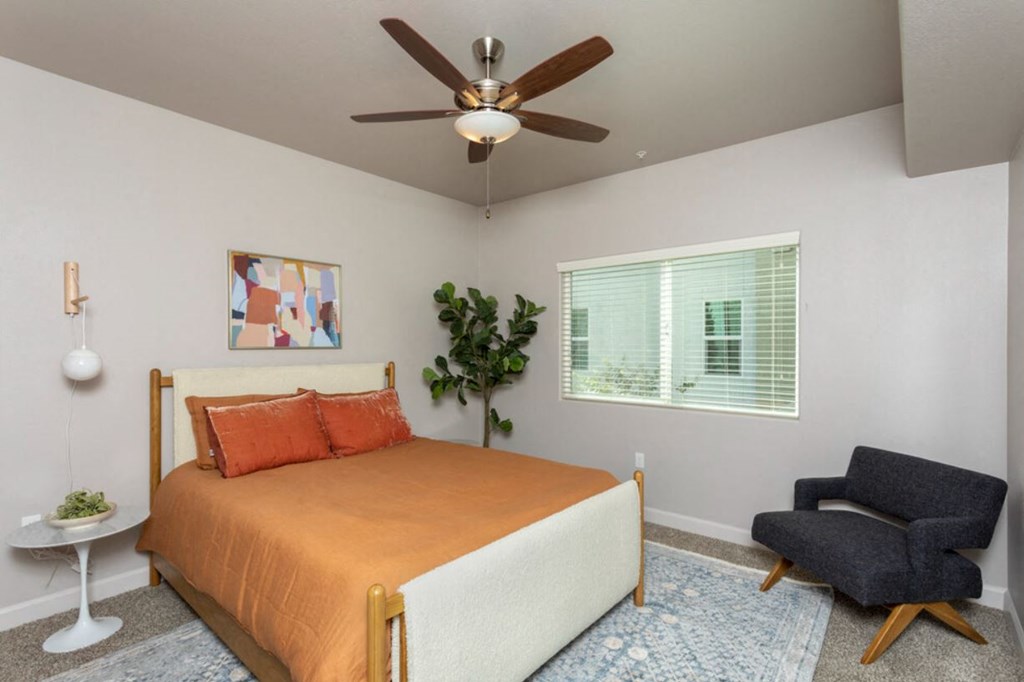 a bedroom with a bed and a ceiling fan