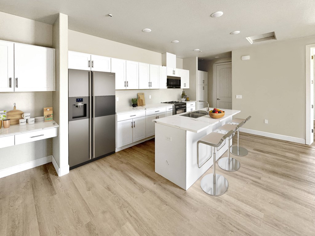 a large white kitchen with stainless steel appliances and a white island