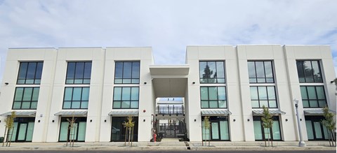 A white building with a black gate in front.