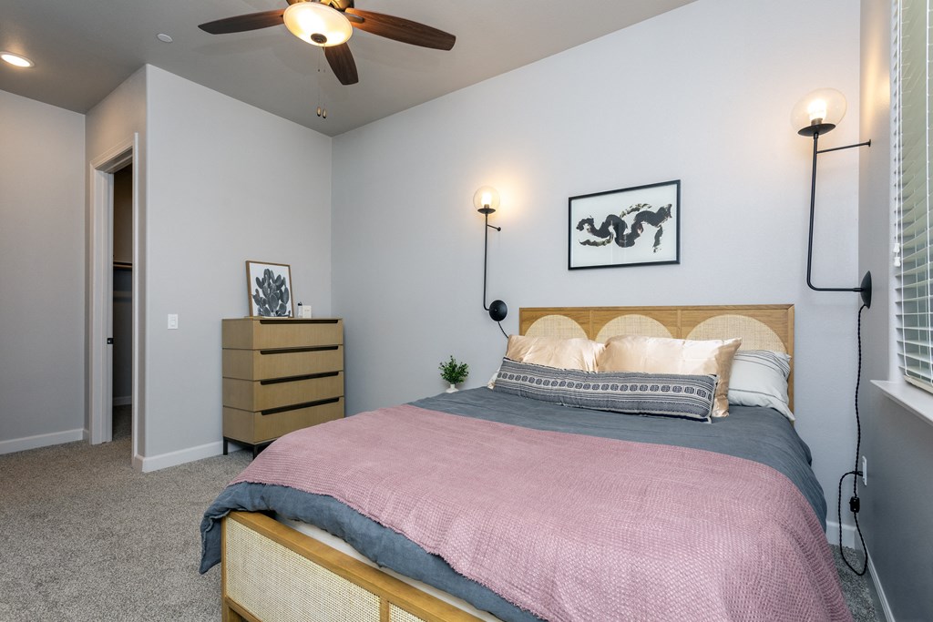 a bedroom with a bed and a ceiling fan