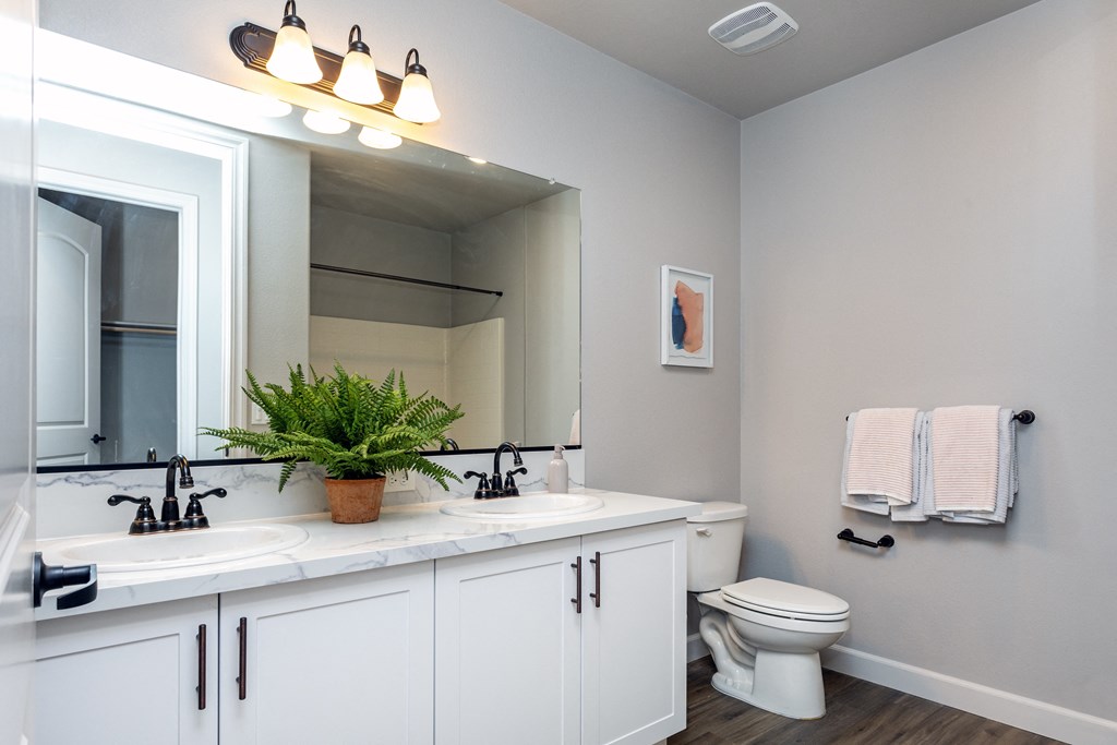 a bathroom with white cabinets and a white toilet