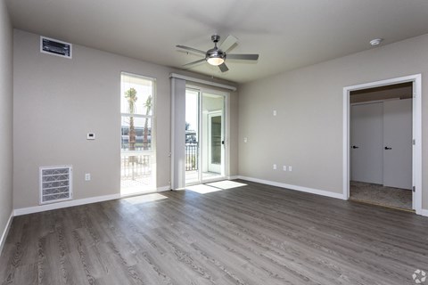 the living room of an empty house with a ceiling fan