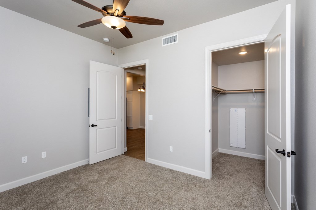 a bedroom with a ceiling fan and closet