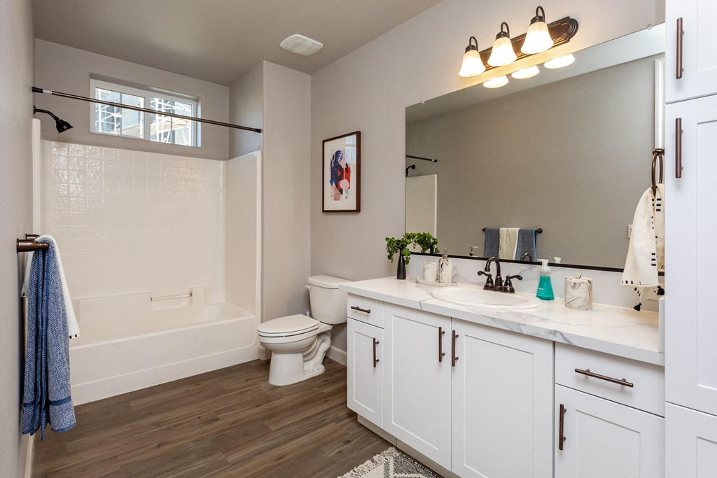 a bathroom with white cabinets and a white bathtub