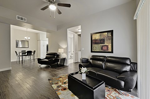 a living room with leather furniture and a ceiling fan