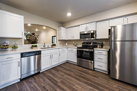 a kitchen with stainless steel appliances and white cabinets