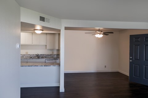 A room with a ceiling fan and a wall-mounted light fixture.