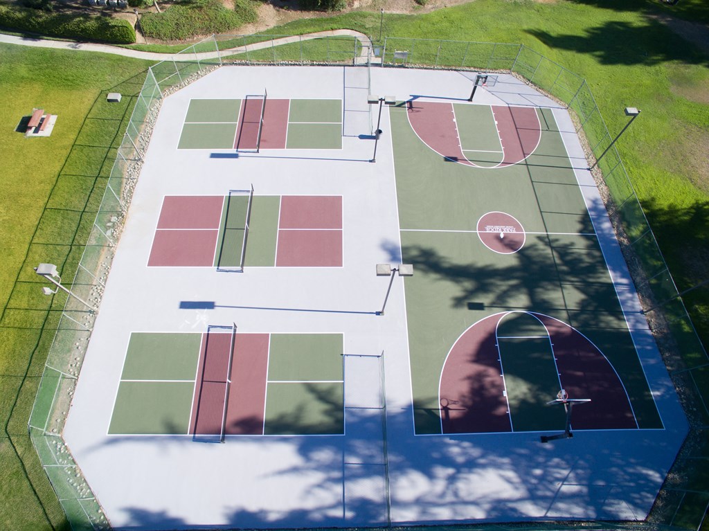 An aerial view of a sports complex with pickleball and basketball courts.
