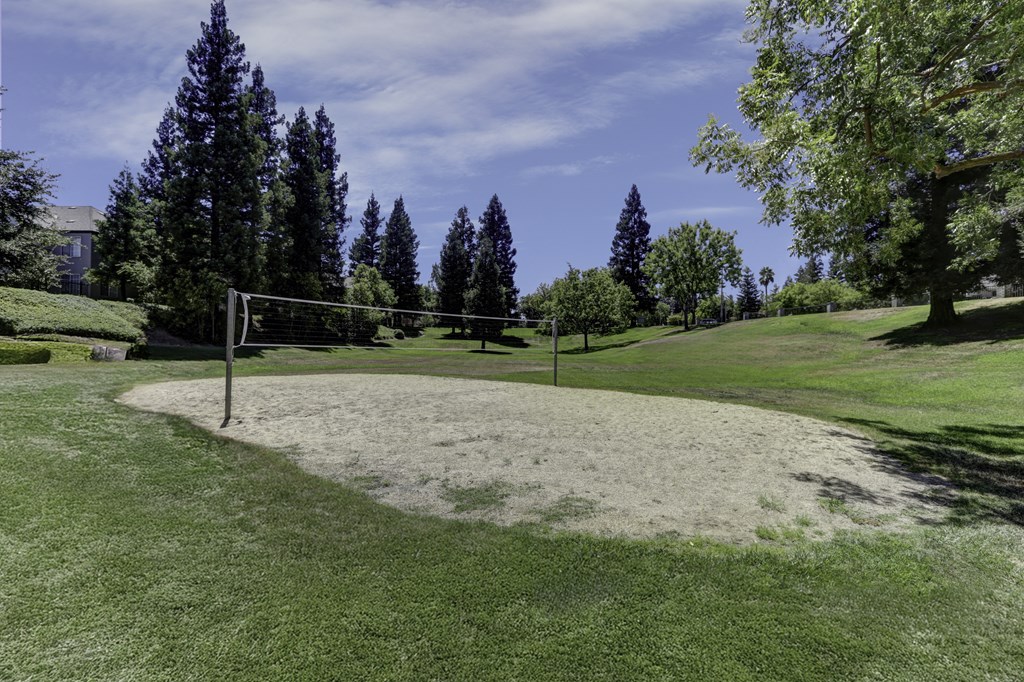 A volleyball court in the middle of a grassy field.