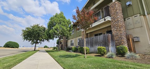 an apartment building with a sidewalk and trees