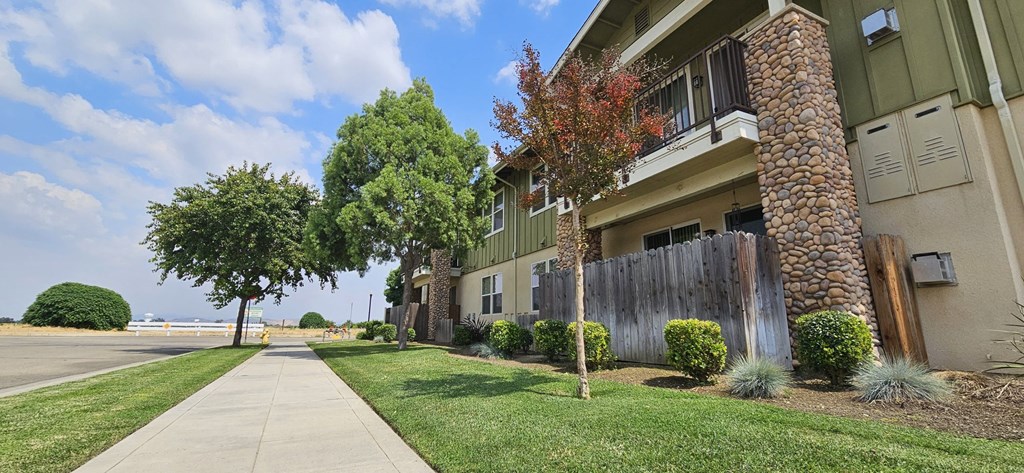 an apartment building with a sidewalk and trees