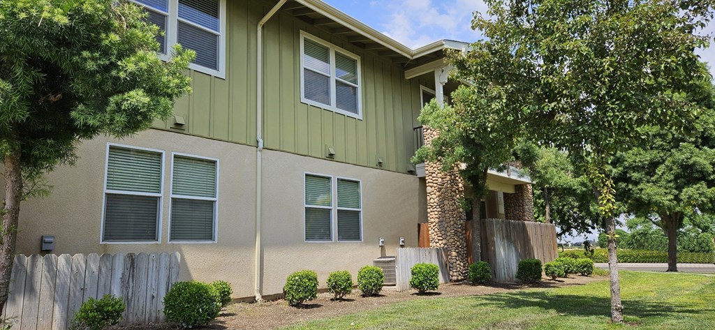 the front of a house with a yard and trees