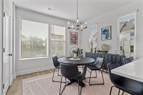A dining room with a round table and chairs.
