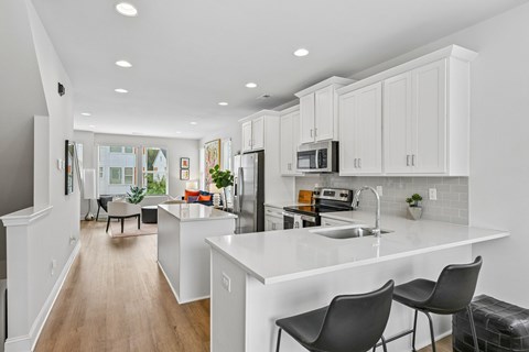 A modern kitchen with white cabinets and a large island.