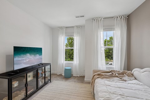A modern bedroom with a large bed and a television.