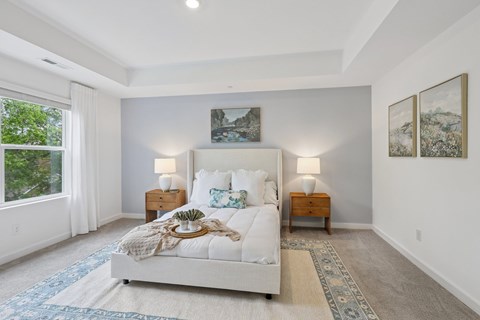 A bedroom with a large bed and two lamps.